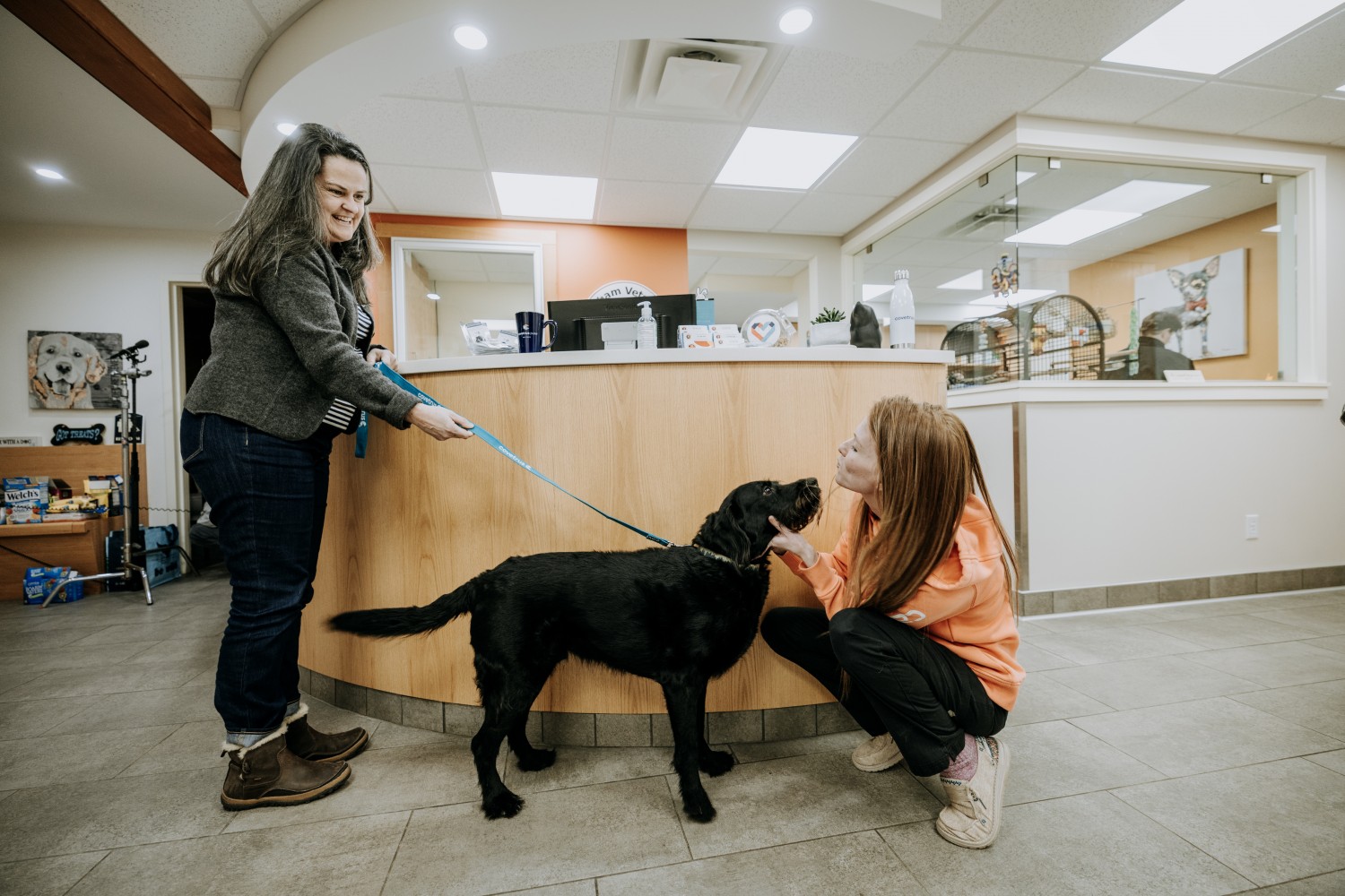 Why you'll love working here - staff, client & dog in reception area.